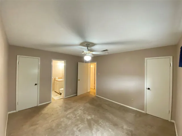 an empty room with closet and a chandelier fan