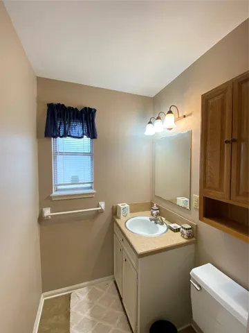 a bathroom with a granite countertop sink toilet and mirror