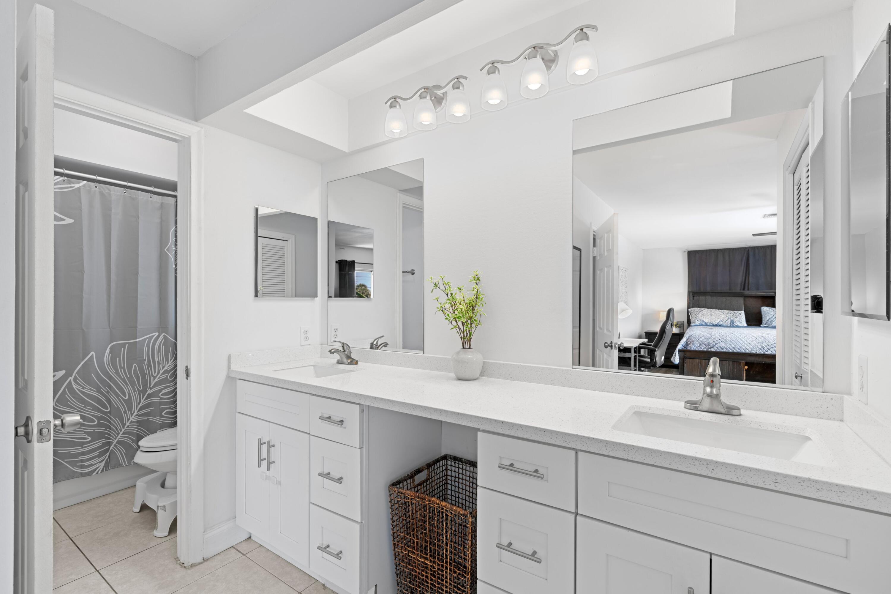 419 Pine Tree Court, Unit 21 Atlantis, FL 33462 - Photo 11 of 22 a bathroom with a sink vanity and mirror
