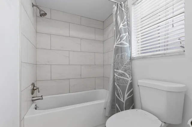 a white toilet and tub sitting next to a white sink