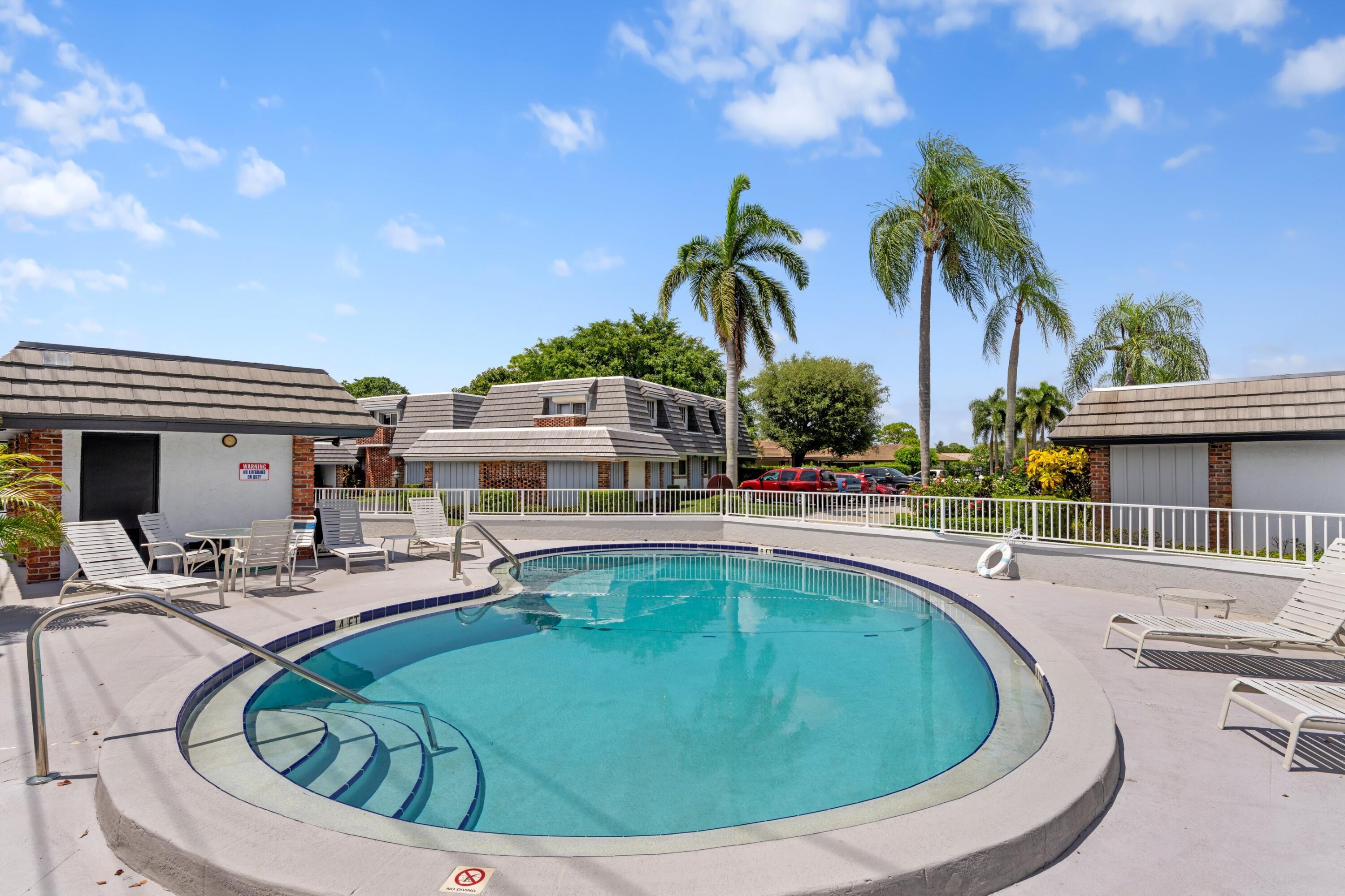 419 Pine Tree Court, Unit 21 Atlantis, FL 33462 - Photo 20 of 22 a view of outdoor space with swimming pool and seating