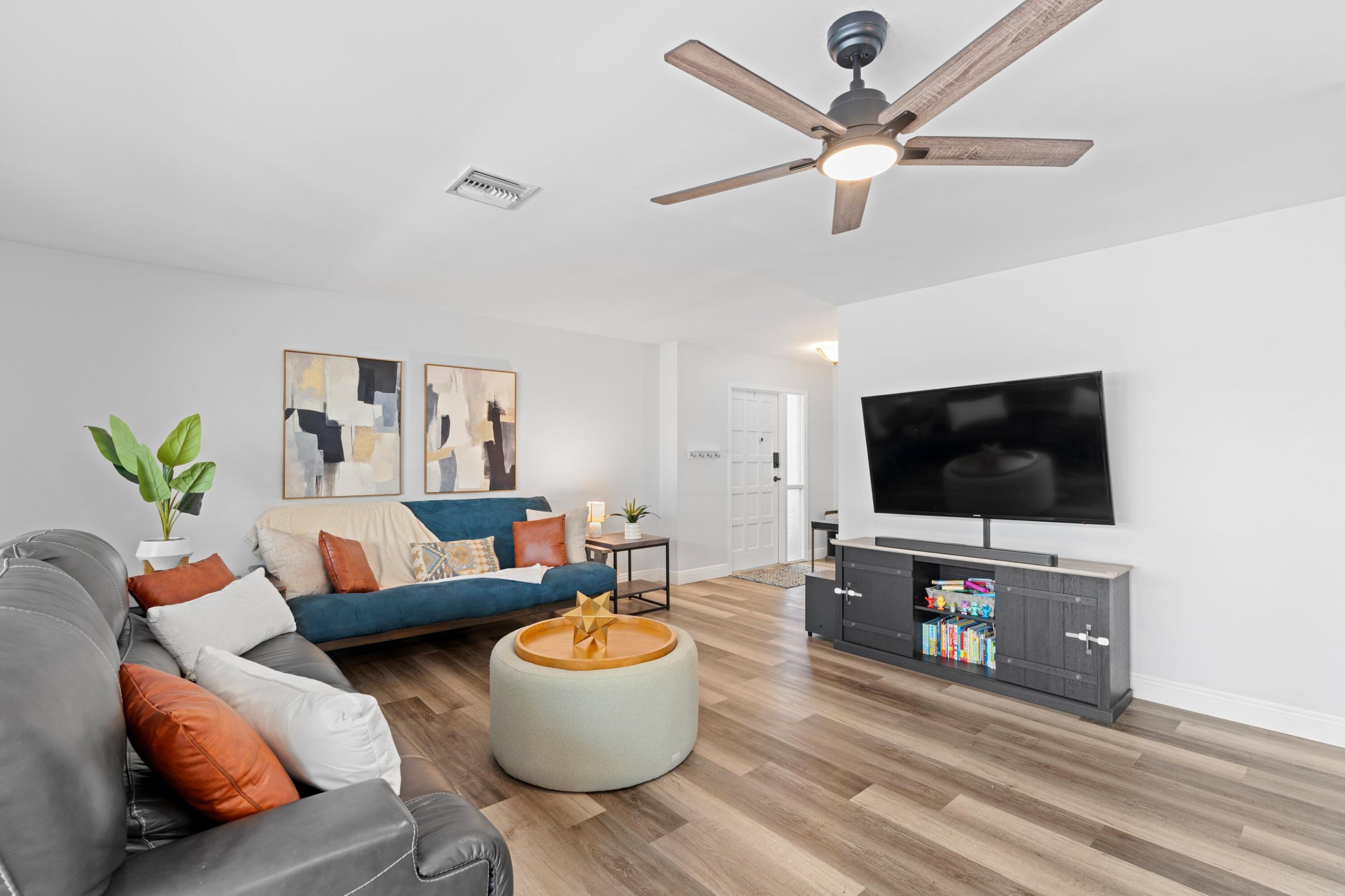 419 Pine Tree Court, Unit 21 Atlantis, FL 33462 - Photo 4 of 22 a living room with furniture and a flat screen tv