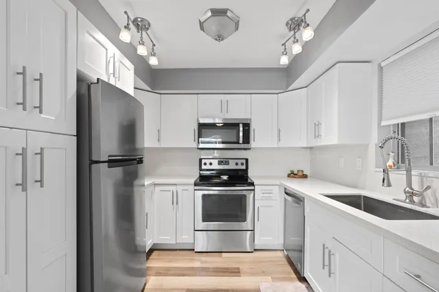 a kitchen with stainless steel appliances a refrigerator sink and cabinets