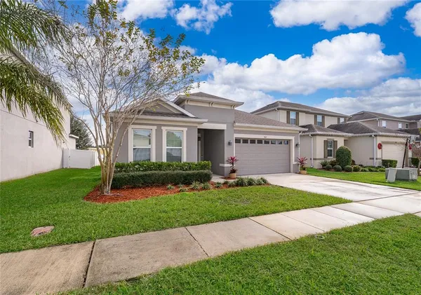 a view of a white house with a yard and plants