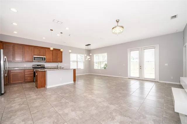 a large kitchen with granite countertop a stove a sink dishwasher and a refrigerator