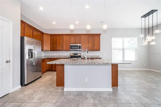 a kitchen with stainless steel appliances granite countertop a refrigerator and a sink