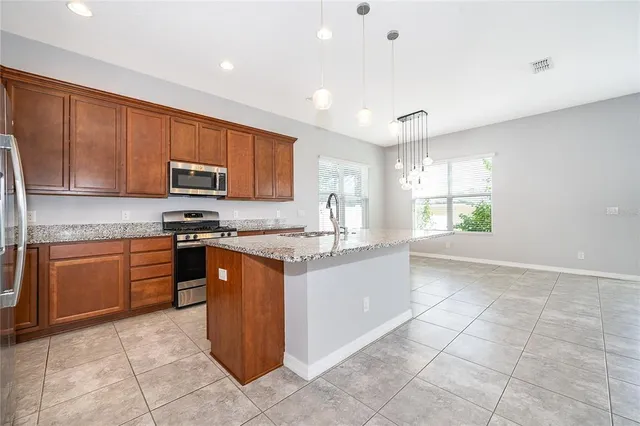 a kitchen with stainless steel appliances granite countertop a stove top oven a sink a counter top space and cabinets
