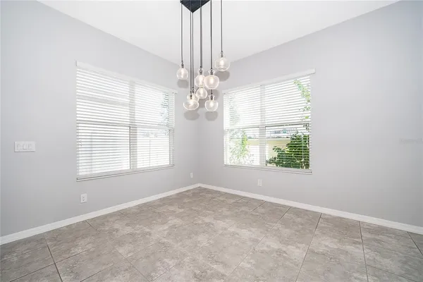 an empty room with a windows and chandelier