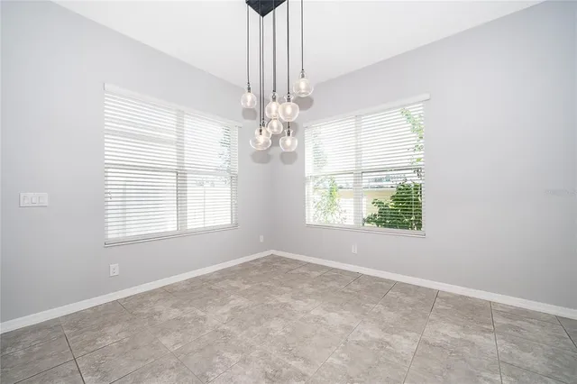 an empty room with a windows and chandelier