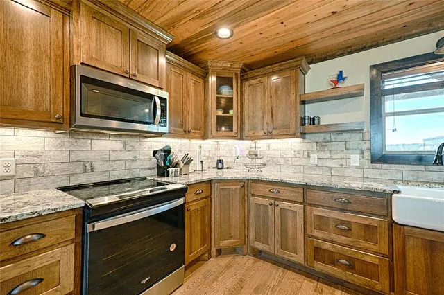 a kitchen with stainless steel appliances granite countertop a sink stove microwave and cabinets