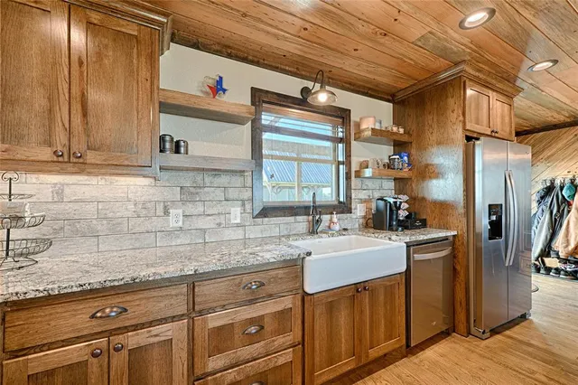 a kitchen with stainless steel appliances granite countertop a sink stove and cabinets