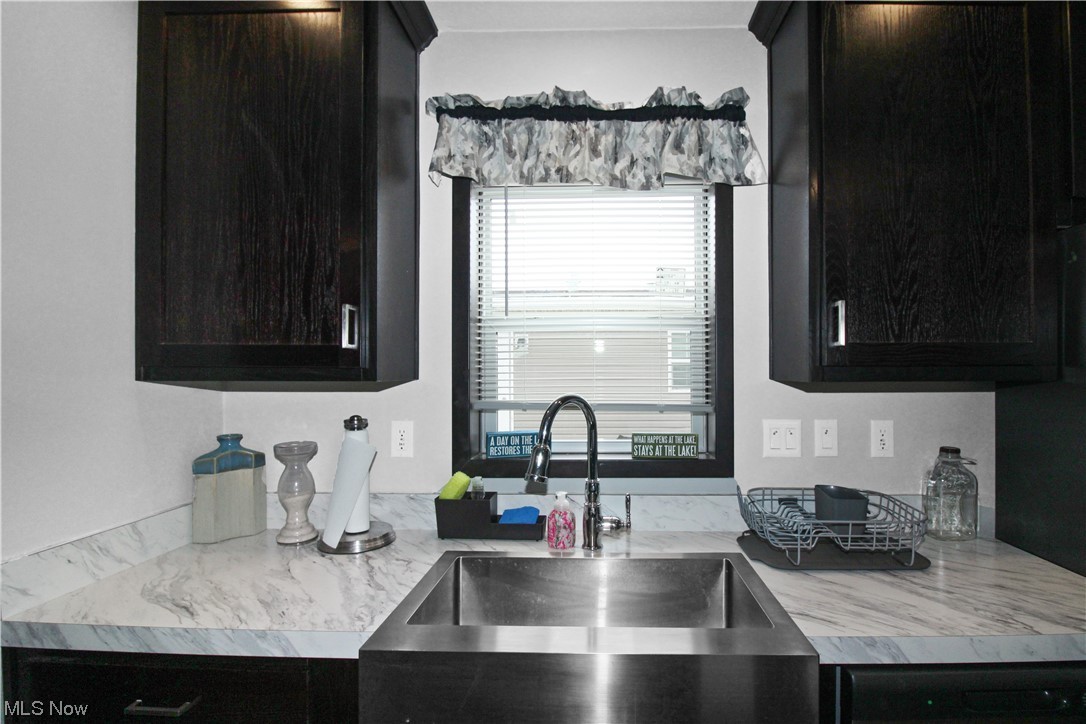 1609 Coldwater Crossing Road Lakeside Marblehead, OH 43440 - Photo 25 of 38 Kitchen featuring dishwashing machine, dark brown cabinets, and sink