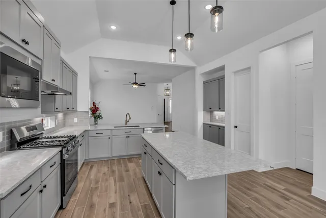 a kitchen with a sink stove and cabinets