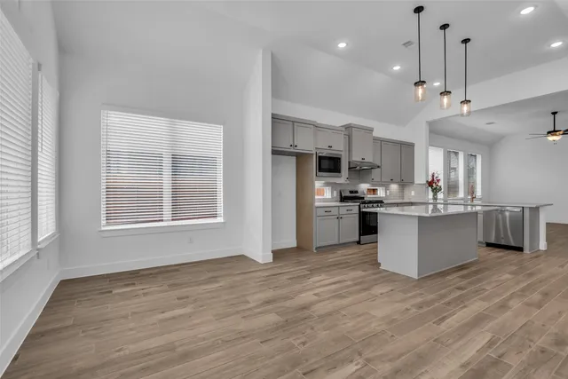 a large kitchen with kitchen island a refrigerator a center island a stove and a window