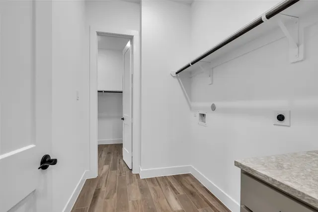 a view of a hallway with wooden floor and closet