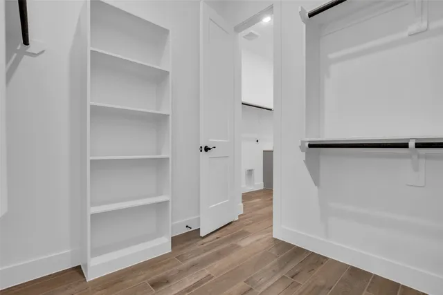 a view of walk in closet with empty racks