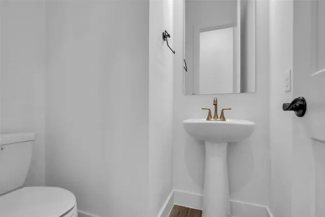 a bathroom with a sink toilet and mirror