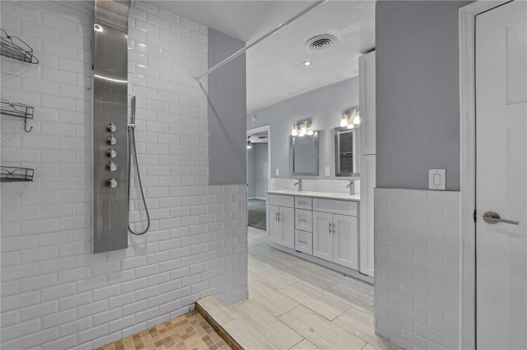 2105 Fortview Road Austin, TX 78704 - Photo 24 of 37 A well-appointed primary bathroom features a spacious shower with modern fixtures and a dual vanity with ample counter space.