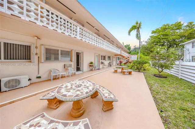a swimming pool with some potted plants and large tree