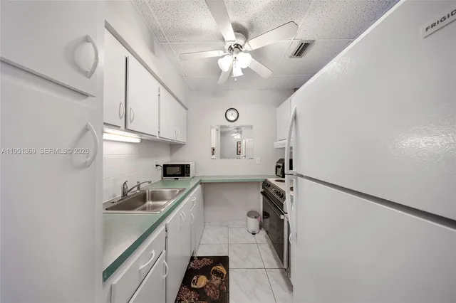 a kitchen with a sink appliances and cabinets
