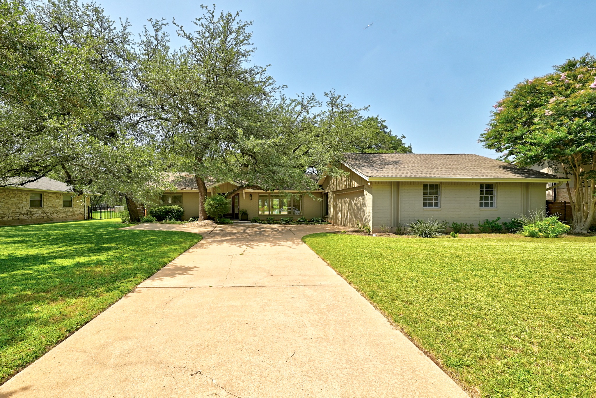 8608 Crest Ridge Circle Austin, TX 78750 - Photo 3 of 38 A graceful residence with a broad driveway and mature shade trees, offering both privacy and curb appeal.