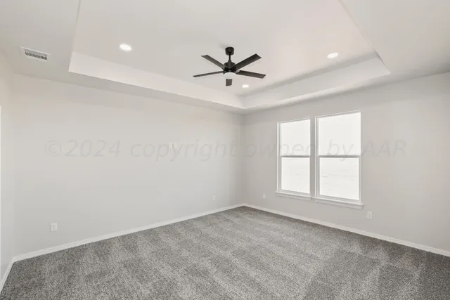 an empty room with windows and ceiling fan
