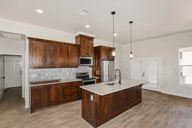 a kitchen with a sink stove and wooden floor