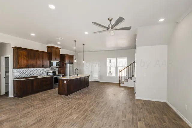 a large kitchen with stainless steel appliances granite countertop a stove and a refrigerator