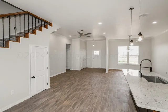 a view of a kitchen with a sink and wooden floor