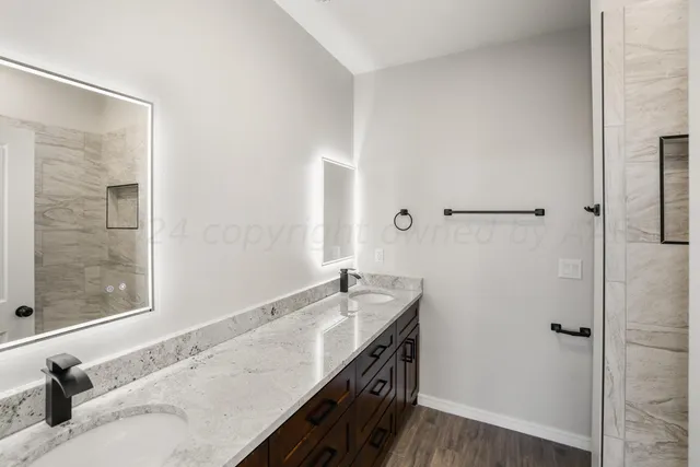 a bathroom with a granite countertop sink and a mirror