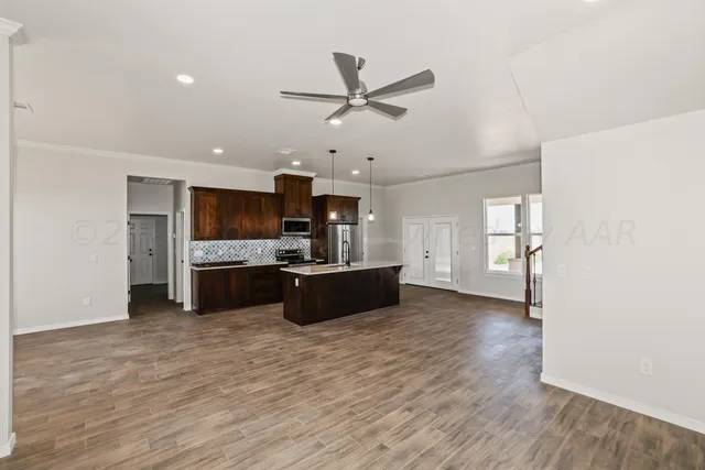 a large kitchen with cabinets wooden floor and stainless steel appliances