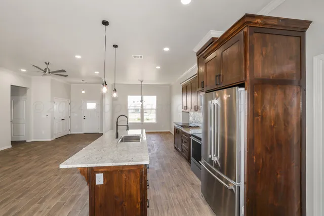 a kitchen with kitchen island white cabinets and stainless steel appliances
