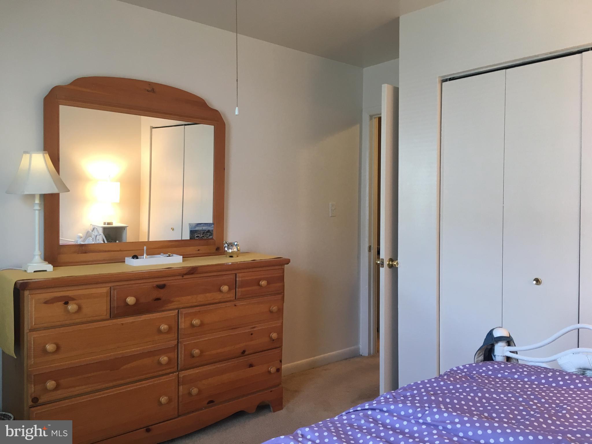 7110 Rutherford Green Circle Baltimore, MD 21244 - Photo 20 of 26 a bedroom with a bed and a mirror on dresser