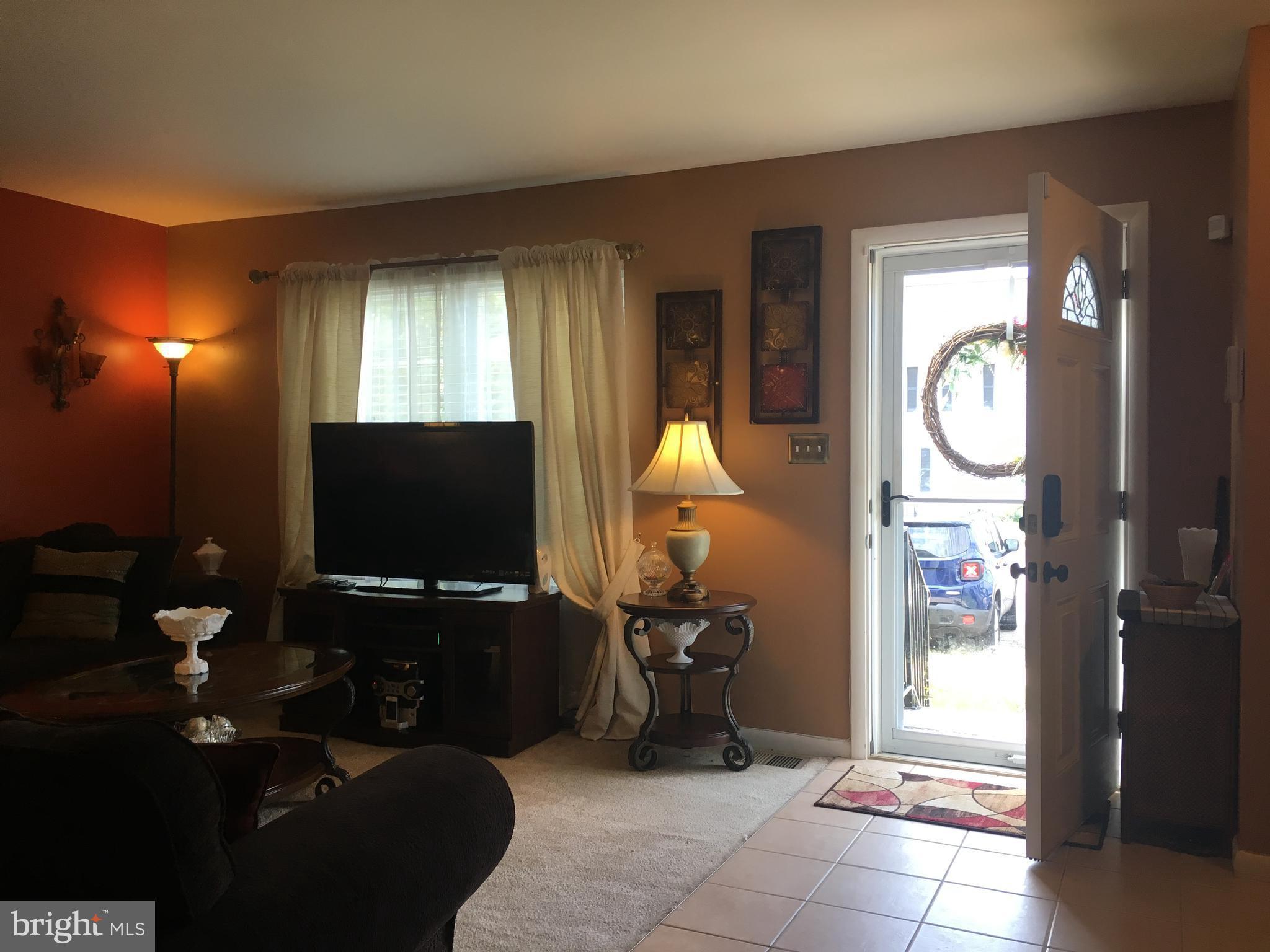7110 Rutherford Green Circle Baltimore, MD 21244 - Photo 6 of 26 a living room with furniture a flat screen tv and a window