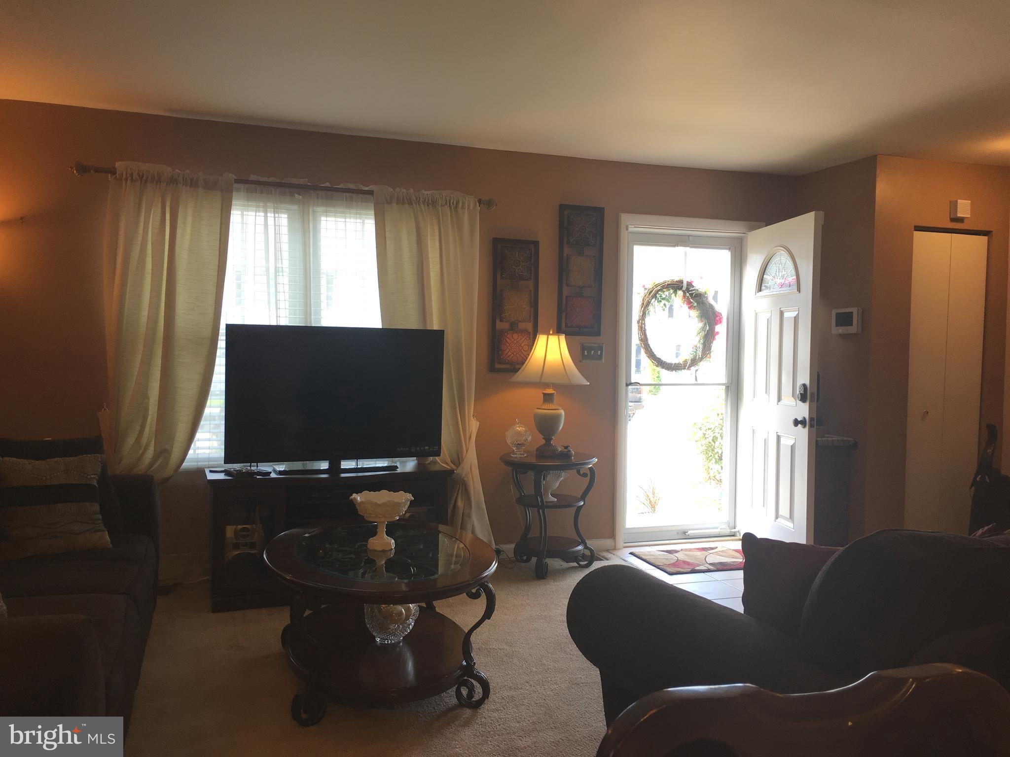 7110 Rutherford Green Circle Baltimore, MD 21244 - Photo 7 of 26 a living room with furniture and a flat screen tv