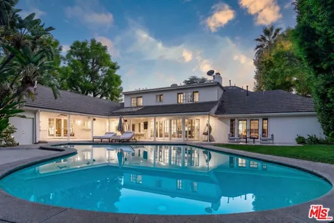 a view of a house with swimming pool and sitting area