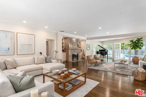 a living room with fireplace furniture and a large window