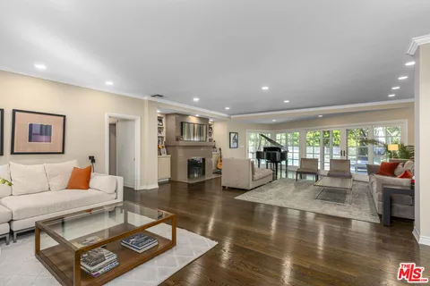 a living room with fireplace furniture and a large window