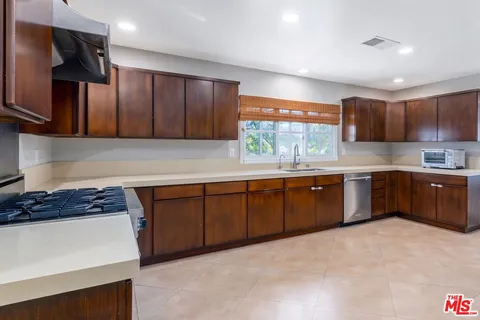a kitchen with stainless steel appliances granite countertop a stove a sink dishwasher and a refrigerator