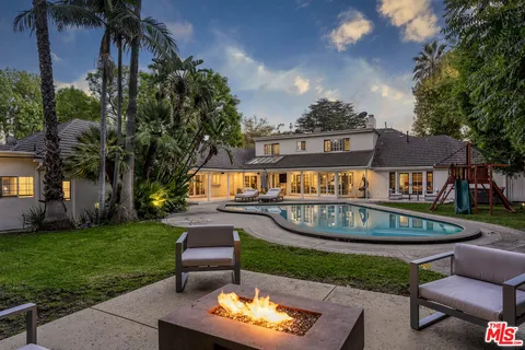 a view of a house with backyard and sitting area