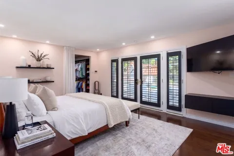 a spacious bedroom with a large bed and a flat screen tv