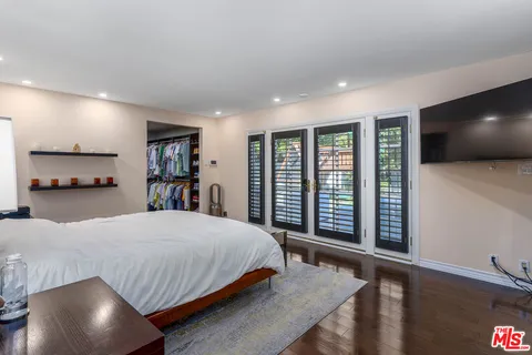 a bedroom with a large bed and a flat screen tv