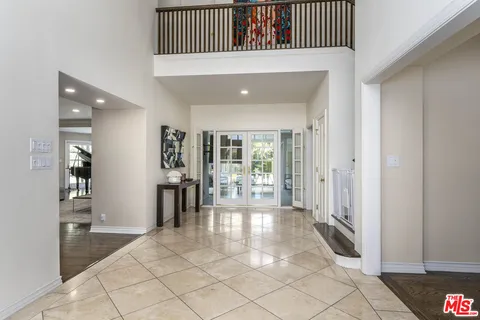 a view of a hallway with wooden floor and a living room