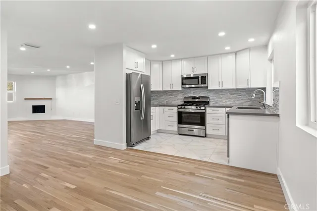 a view of kitchen with kitchen island microwave and cabinets