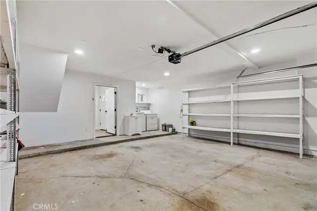 a view of an empty room with wooden floor and stairs