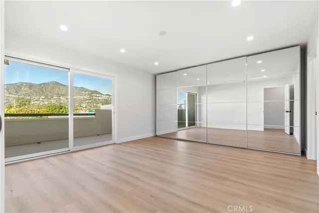 a view of empty room with wooden floor and fireplace