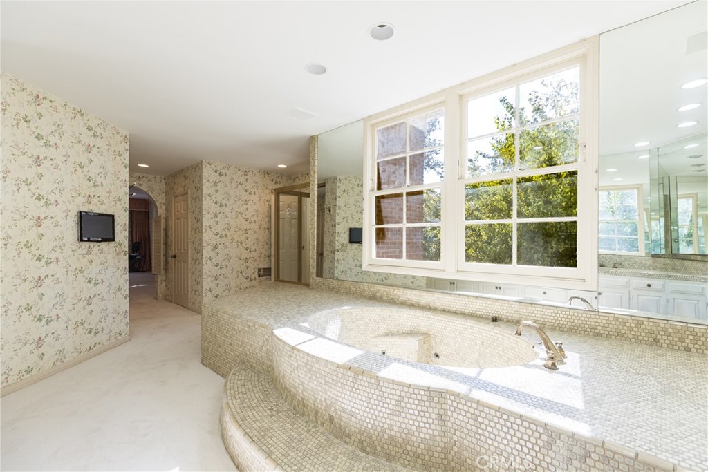 12386 Ridge Circle Los Angeles, CA 90049 - Photo 40 of 56 a bathroom with a tub sink and large window