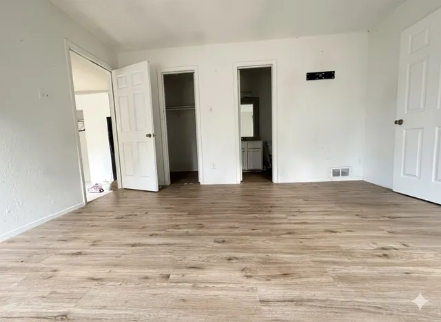 a view of empty room with wooden floor