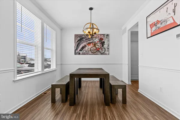 a dining room with a window and wooden floor