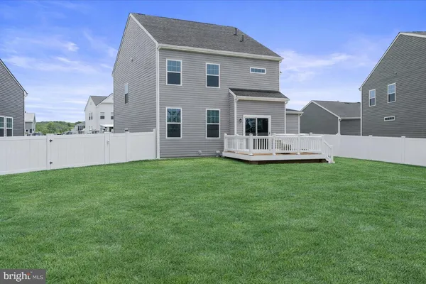 a front view of a house with a yard and fence